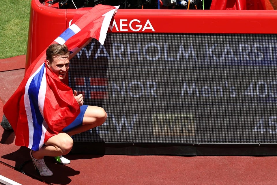 Het klassieke beeld. Atleet hult zich in vlag en poseert glimlachend voor een nieuwe recordtijd. Karsten Warholm voert na zijn 400m horden het ritueel uit.