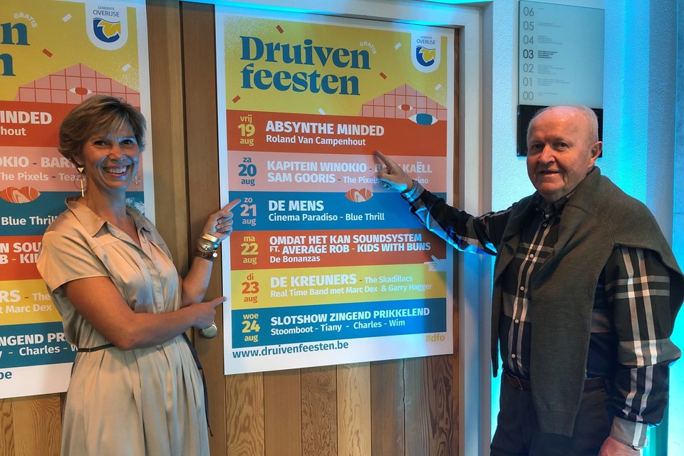 Burgemeester Inge Lenseclaes en schepen Leo Van den Wijngaert bij de affiche van de Druivenfeesten.