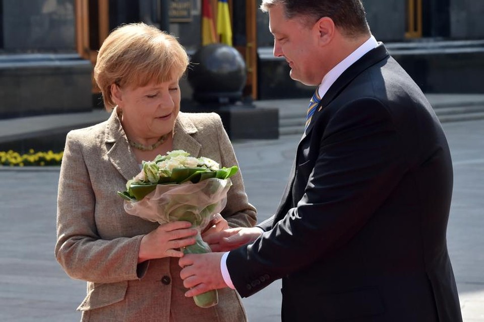 Merkel krijgt bloemen van de Oekraïense president Porosjenko