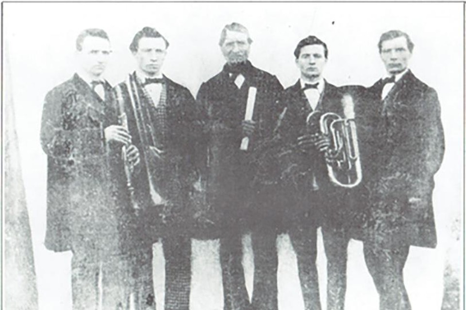 De Koninklijke Harmonie Sint-Cecilia werd 200 jaar geleden opgericht door Karel Seynaeve (midden op de foto). Hij was ook de eerste dirigent en poseert met zijn zonen. 