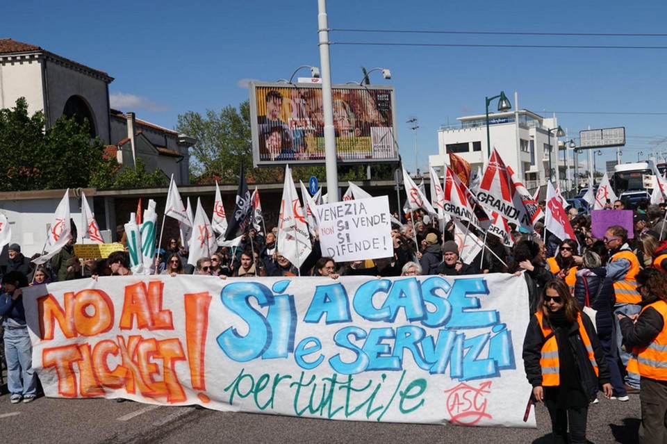 Een protestmars eind april in Venetië. Op het spandoek staat links een afkeuring van het ingevoerde toeristenticket wegens niet efficiënt, rechts: “Ja voor huizen en diensten voor iedereen”.