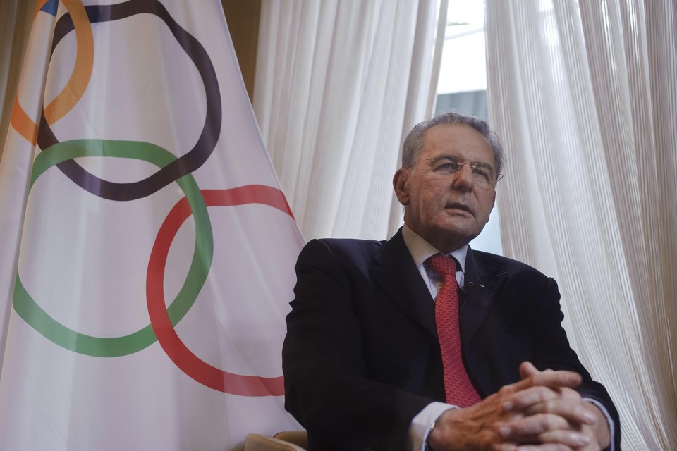 Jacques Rogge bij de olympische ringen, waarmee hij onlosmakelijk verbonden is.
