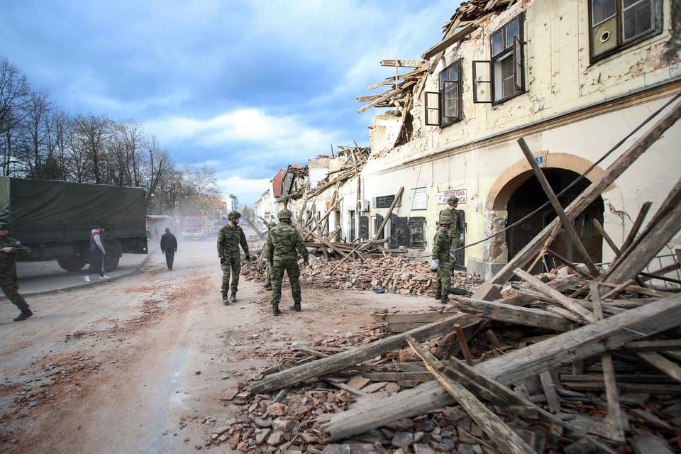 Kroatische soldaten bij vernietigde gebouwen in Petrinja, het epicentrum van de aardbeving.