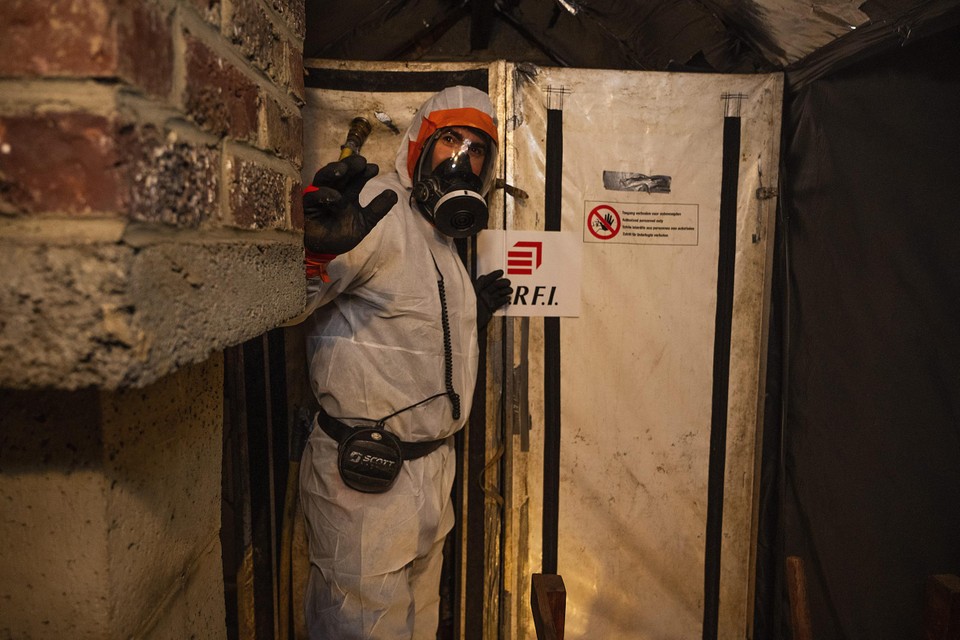 Werklui die asbest verwijderen, trekken daarvoor speciale pakken aan. 