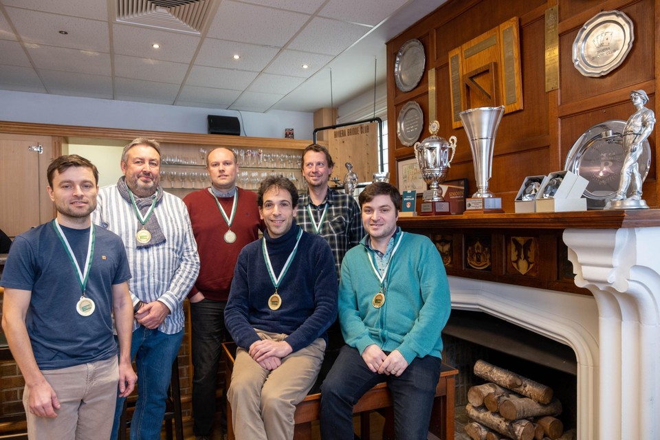 De zes Champions’ Cup-winnaars van Riviera Deurne bij de trofeeënmuur van hun club. De meest recent gewonnen en meest prestigieuze cup staat nog in Helsinki, maar de gouden medaille kregen ze gelukkig wel mee. 