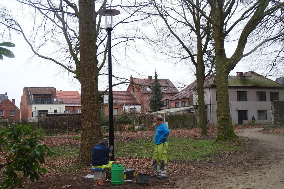 Werknemers van Fluvius plaatsen verlichting in het Mariapark in Vosselaar.
