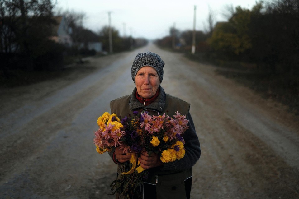 Een vrouw staat klaar met bloemen om Oekraïense troepen te verwelkomen die haar dorp in de buurt van Cherson komen bevrijden van de Russische bezetters.  
