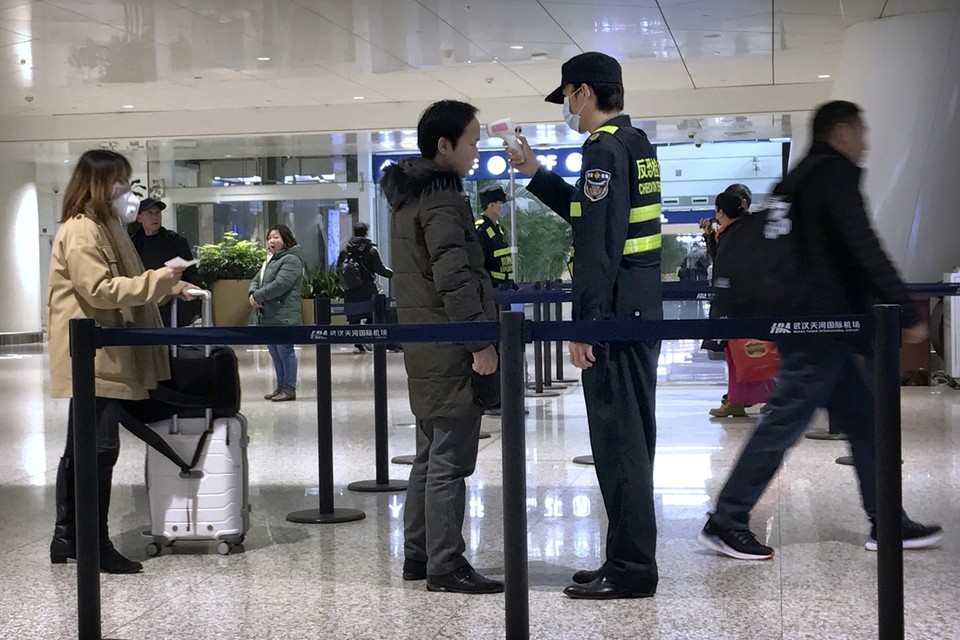 Screening met een infrarood thermometer op de luchthaven van Wuhan 