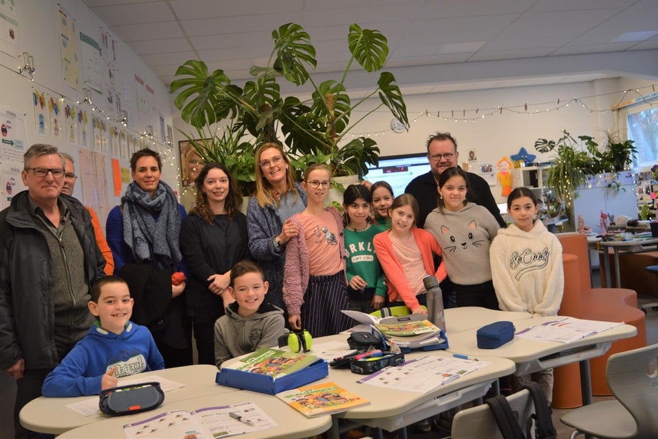 Burgemeester Johan De Ryck, schepen Annelies Crets, Katinka Vandevelde, directeur Saskia Roets en meester Gert met enkele leerlingen in de flexiklas waar het derde en het vierde samen les krijgen. Foto KMA