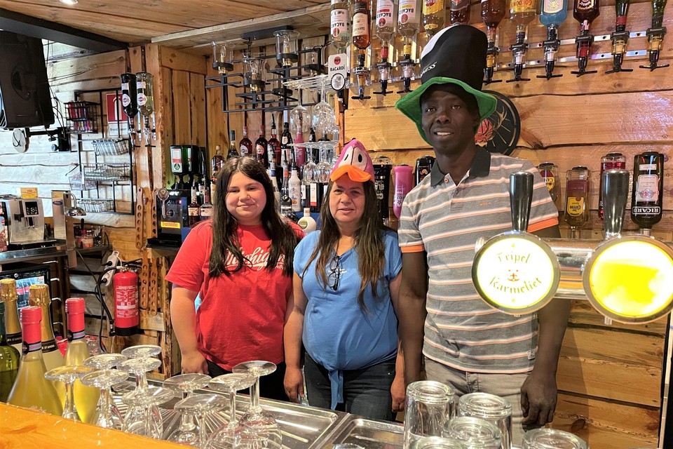Thailia, Chantal en Lamine achter de toog, met tientallen flessen in de achtergrond. “We bieden elke week meer dan 100 verschillende shots aan.”