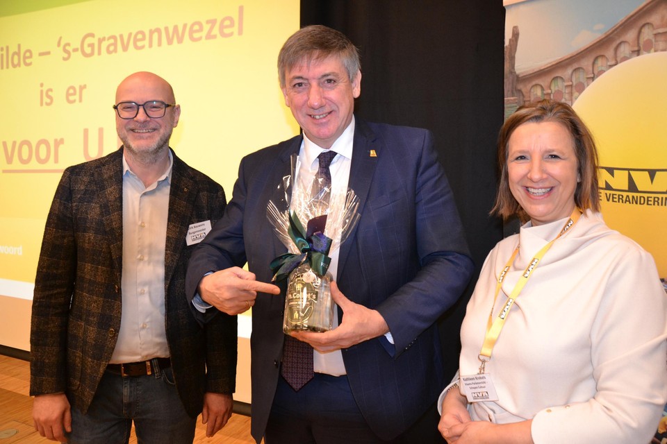 Dirk Bauwens, die precies tien jaar burgemeester is, en schepen Kathleen Krekels overhandigden eregast Jan Jambon een streekproduct: gin van Philip Collet uit ‘s-Gravenwezel..