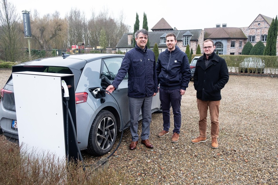 Zaakvoerder Koen Vandermeulen, verkoopsmanager Stijn Vranckaert en operationeel manager Stijn De Vidts aan een van de twee al geplaatste laadpalen op de parking van feestzaal De Mooie Molen: “Iedereen kan er gebruik van maken.”
