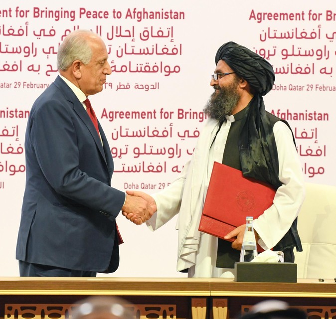 Amerikaans gezant Zalmay Khalilzad en medeoprichter van de taliban Abdul Ghani Baradar bij het ondertekenen van het eerdere akkoord in 2020.