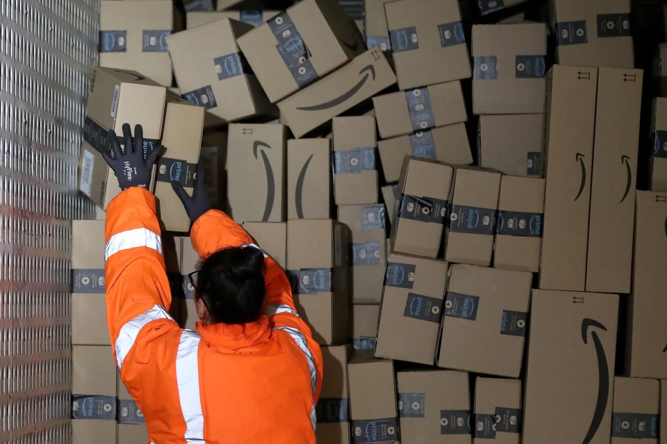  Een Amazon-medewerker in Duitsland stapelt pakjes in een vrachtwagen. Amazon hoopt ook in Vlaanderen voet aan de grond te krijgen.