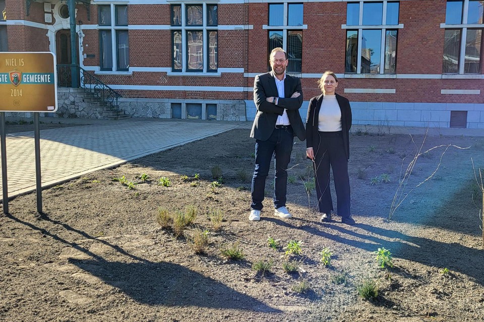 Burgemeester Tom De Vries en schepen Kelly Breugelmans staan in het ‘Wonderwoudje’ dat recent voor het gemeentehuis werd gerealiseerd en voor extra ontharding zorgt.