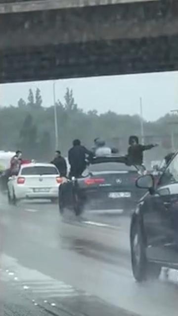 Men hang from cars on Antwerp Ring