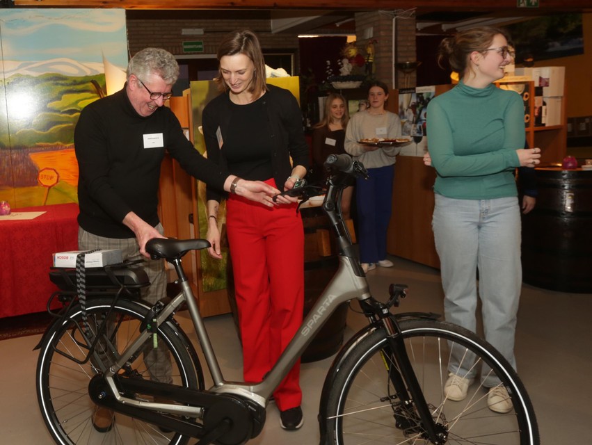 Leo Van Bocxlaer van Het Krantenkopje overhandigt de elektrische fiets aan Caroline Cayman.