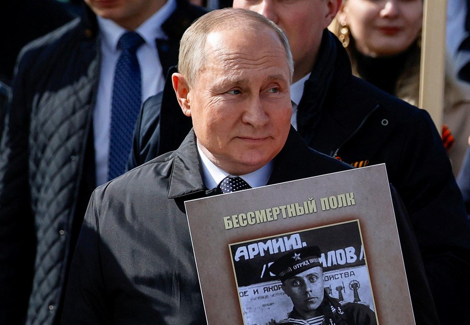 Vladimir Poetin tijdens de 9 mei-viering com een ​​portret van zijn vader die vocht tijdens WOII 