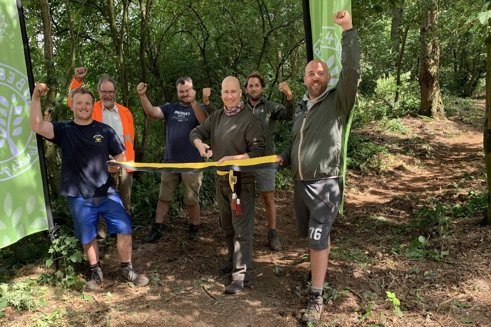 De Geelse milieuschepen Bart Julliams (N-VA) knipt officieel het lintje door van het bos dat Pieter Vanhoof (links), Kevin Vleminx (tweede van rechts) en Jeroen De Muynck (rechts) van Beer 4 Nature samen met vrijwilligers van De Bosgroep Zuiderkempen toegankelijk maakten.