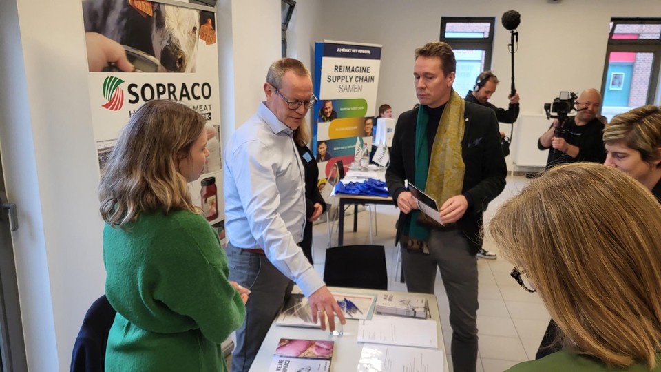 Personeelsdirecteur Hugo Geuens van Sopraco (in licht hemd) legt aan minister Jo Brouns uit dat zijn stapel formulieren snel ingevuld geraakte.