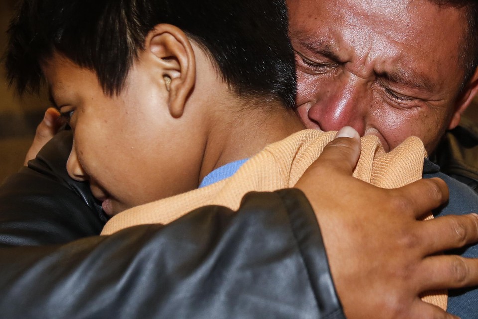 Archiefbeeld: een vader uit Guatemala knuffelt zijn kind nadat ze anderhalf jaar gescheiden waren.