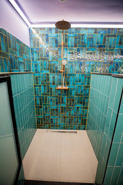 The bathroom, with blue-green tiles and colored grout. 