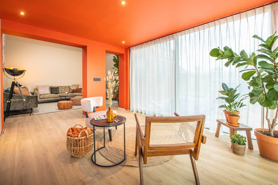 An unrecognizable living room after the renovations, with the much-discussed tangerine-colored walls. 