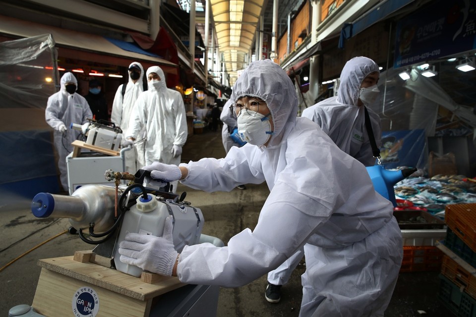 Een team sproeit een desinfecterende vloeistof op een markt in Seoel, Zuid-Korea. Het virus zit intussen in meer dan 30 landen, maar verspreidt zich niet ongecontroleerd. 