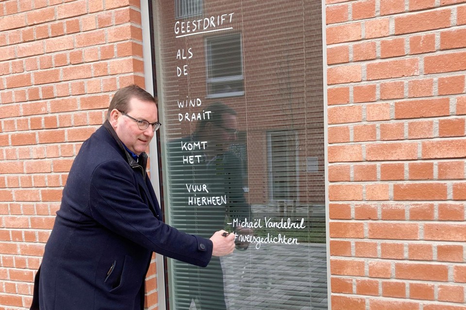 Schepen van Cultuur Stefaan Vercamer bij een van de weesgedichten, die op verschillende ramen in het Oudenaardse straatbeeld zijn aangebracht.