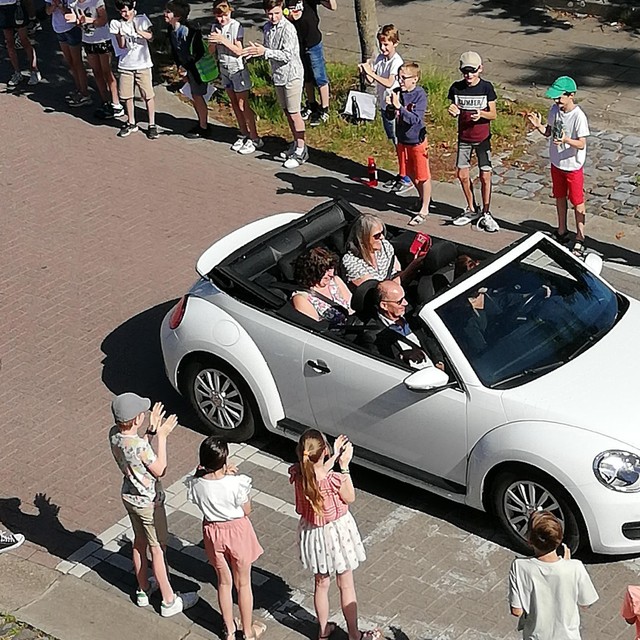 De drie trouwe leerkrachten werden in een open auto naar basisschool Triangel in Vlimmeren gereden. 
