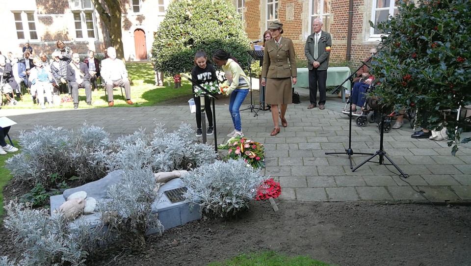 Verschillende verenigingen leggen met hulp van de kinderen kransen neer bij het monument.