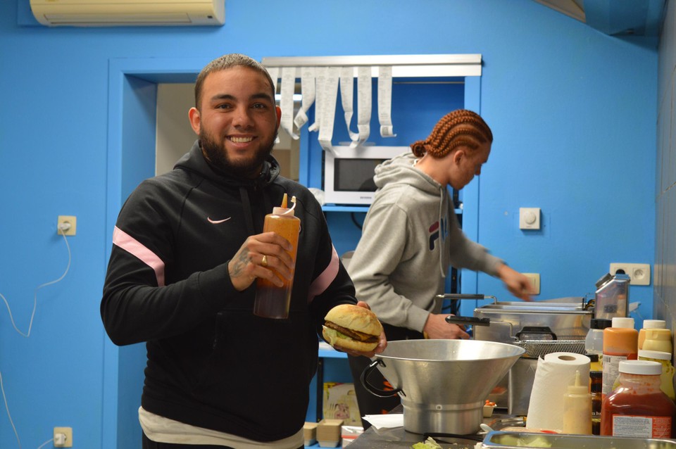 Danrico prepares a burger. 