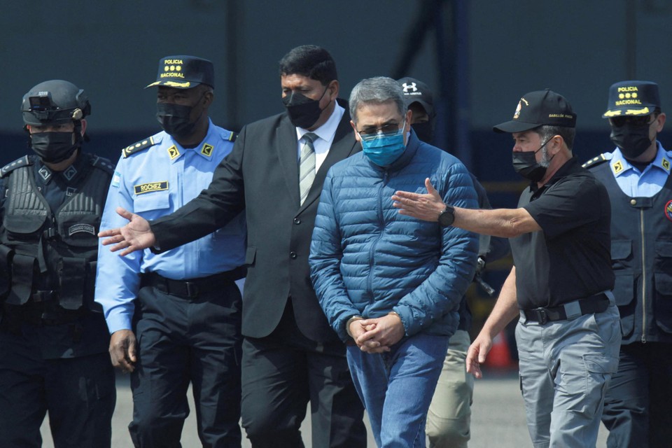 Hernandez (met blauwe jas) wordt naar een vliegtuig van de Amerikaanse DEA geleid. 