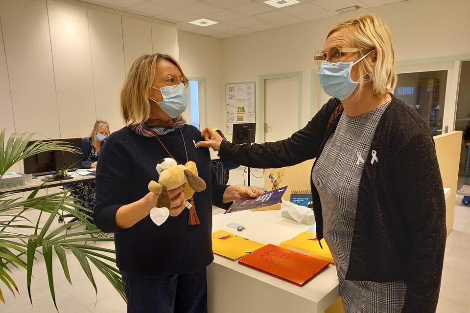 Petra Beyers (rechts) overhandigt de witte lintjes en de knuffelbeer aan Mariëlle Kuypers, directeur van ’t Blokje. 