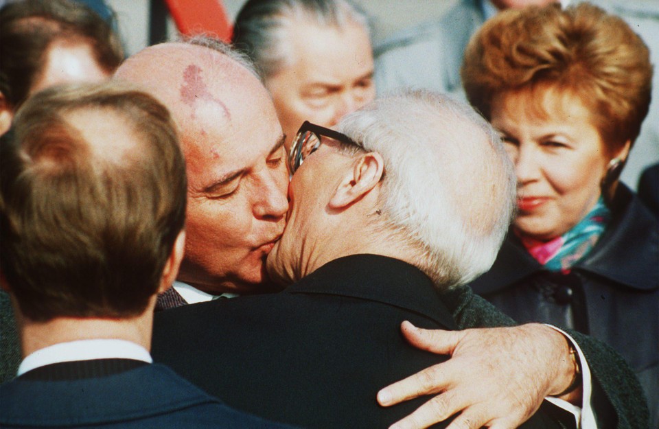 In 1989 kust Gorbatsjov de DDR-leider Erich Honecker, met in de achtergrond zijn vrouw Raisa. 