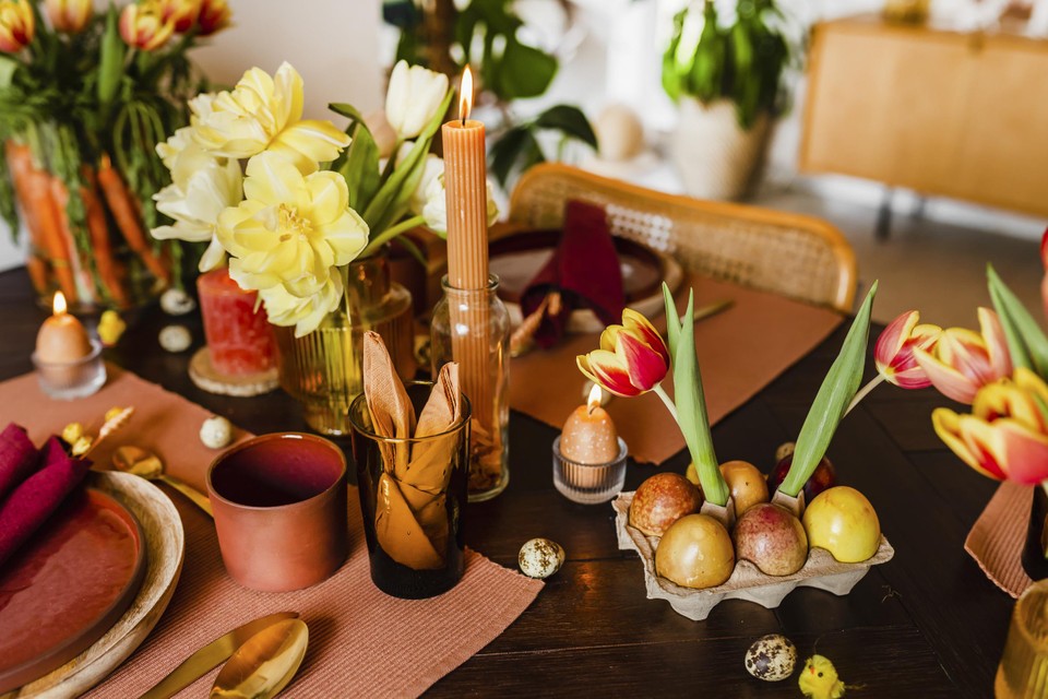 Create an atmosphere with flowers, candles, and vases of different shapes and structures. 