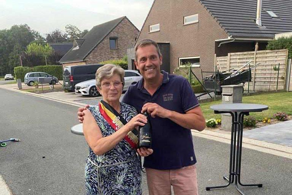 Regine Vanderjeught kreeg een fles bubbels en het tricolorelint uit handen van Pascal Coene van het wijkcomité.