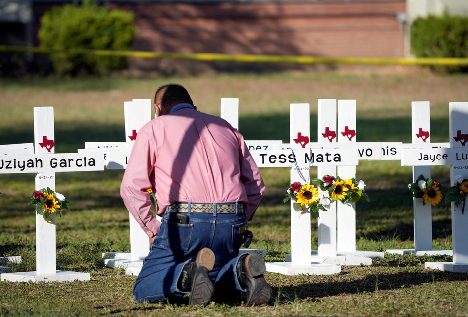 Buiten de school staan witte kruisen met de namen van de slachtoffers. 