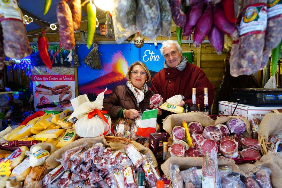 Angela en Salvo Piazza in hun kraam, tussen de pecorino en de salami: “Gent is een soort tweede thuis geworden. We hebben hier vrienden voor het leven gemaakt.”