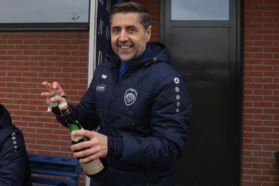 Coach Filip Comptaert ontkurkt de champagne.