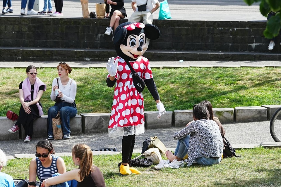 ‘Minnie Mouse’ spreekt mensen aan om samen op de foto te gaan. 