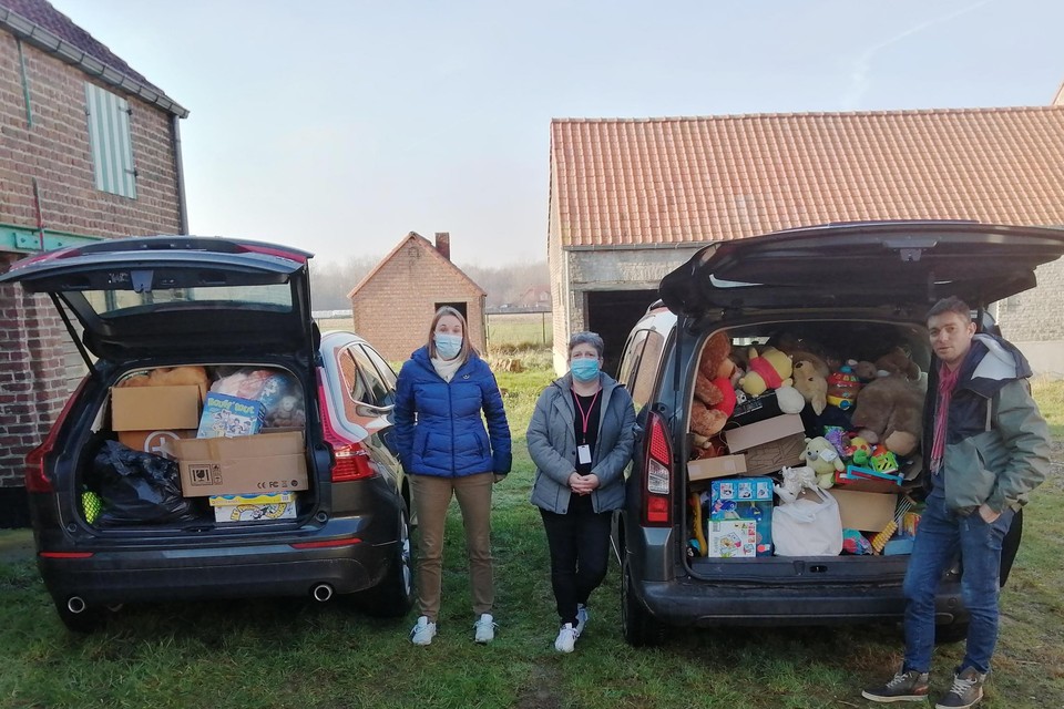 Volgeladen auto’s voor een nieuw transport naar Trooz, nu met speelgoed van MeiseSchenkt, staan klaar. Anouk, Veronique (midden) en Jorgen (rechts) laden de spullen in. 