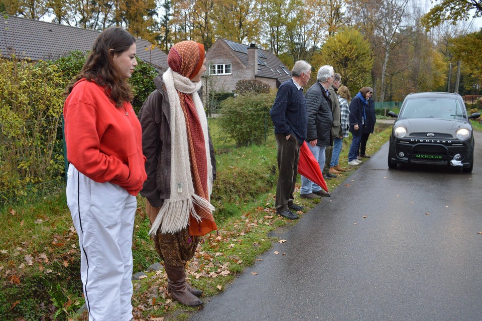 De bewoners van de Gagelhoflaan, met vooraan Lina en Eva, tonen hoe dicht ze tegen de gracht moeten staan om een auto te laten passeren. 