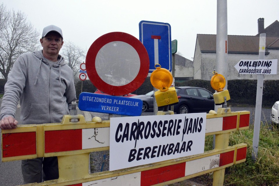 Eddie Jans voorziet pijlen en borden die aanduiden dat zijn zaak bereikbaar is. 