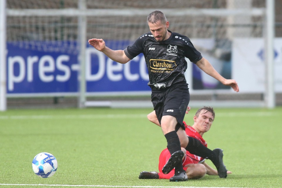 Jonas Capoen met de tackle op Benjamin Lutun, die met twee goals een groot aandeel had in de wederopstanding van Nieuwkerke. 