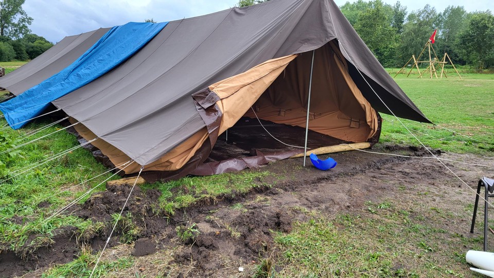 Greppels en zandzakjes konden niet verhinderen dat het water de tenten binnen liep.