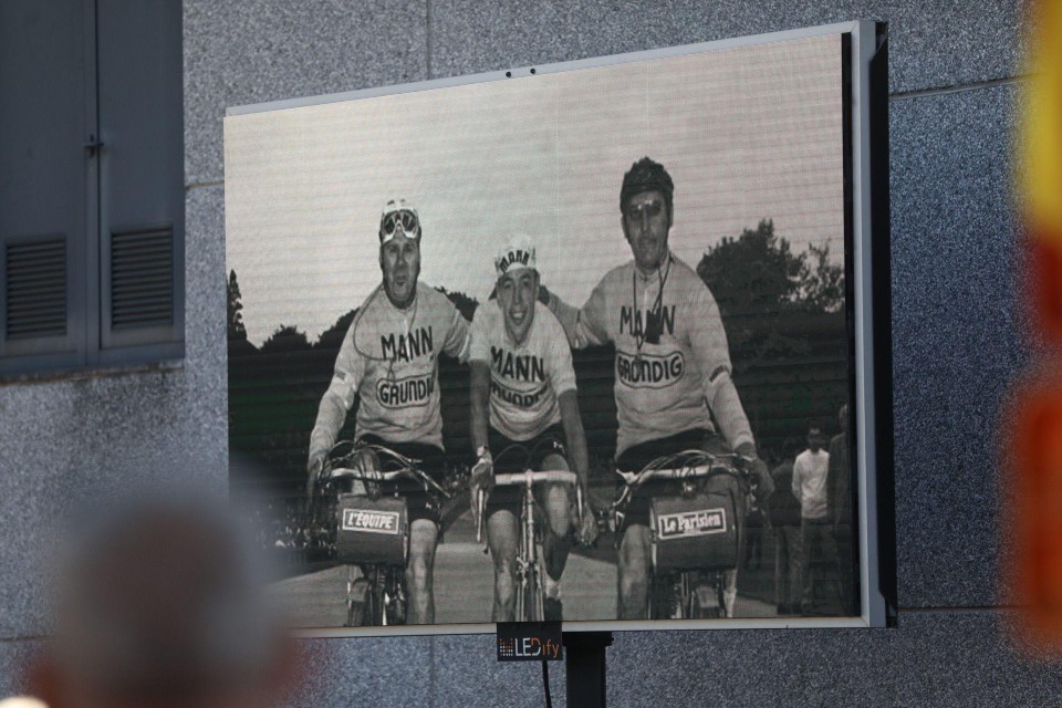 Op de uitvaart worden oude beelden getoond van de wielerkampioen. Ook buiten de zaal kan alles gevolgd worden op groot scherm. 