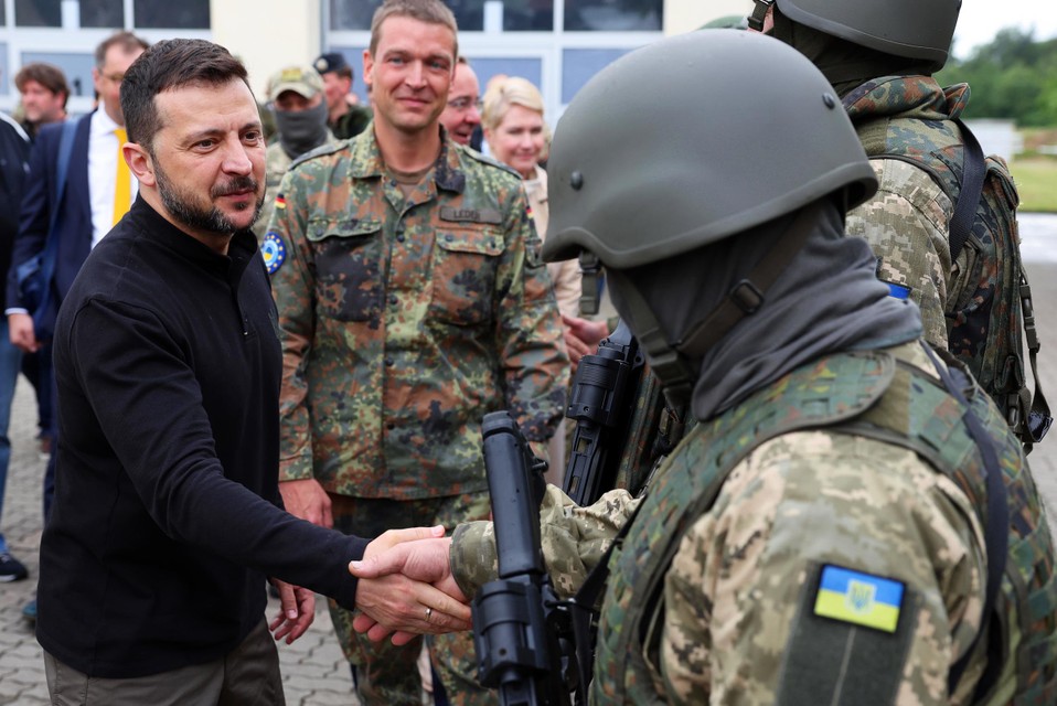 Volodymyr Zelenski (L) verwelkomt Oekraïense soldaten tijdens zijn bezoek aan een militair oefenterrein in Duitsland