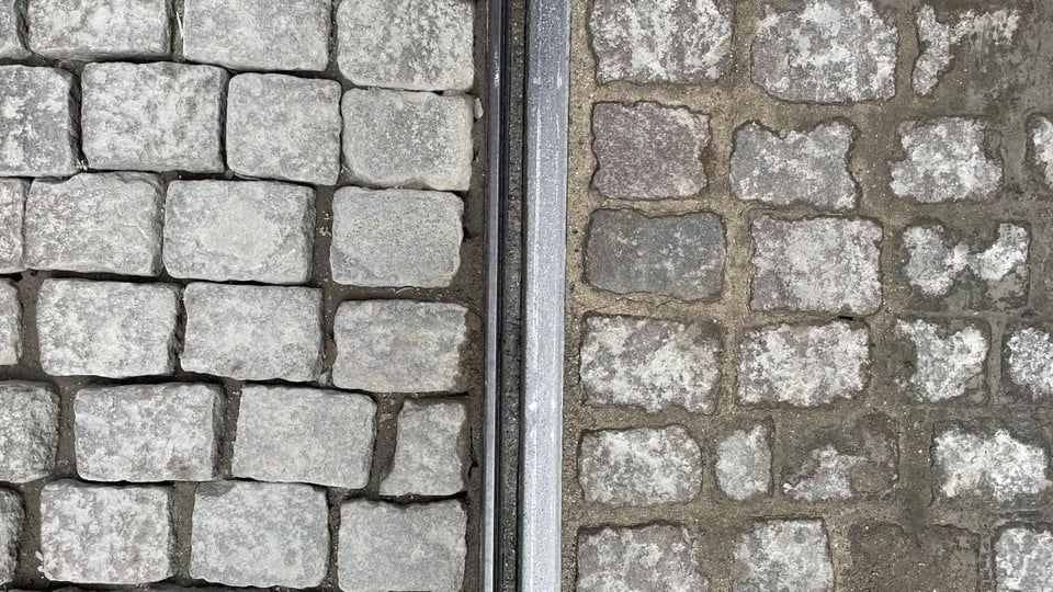 Rechts een slechte kasseistrook, links een herstelde kasseistrook.