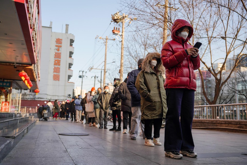 Inwoners van Peking schuiven aan voor een PCR-test. Vanaf maandag zullen de rijen minder lang zijn van zodra een negatieve test voor het openbaar vervoer niet langer nodig is.  